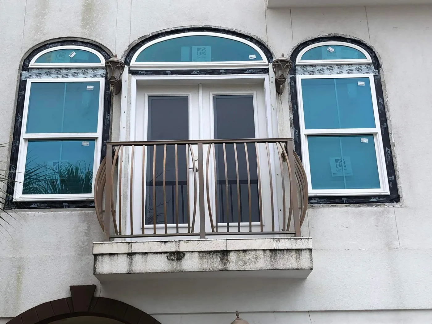 New arched impact-rated windows on a Mediterranean-style 30A home by Lesher Contracting
