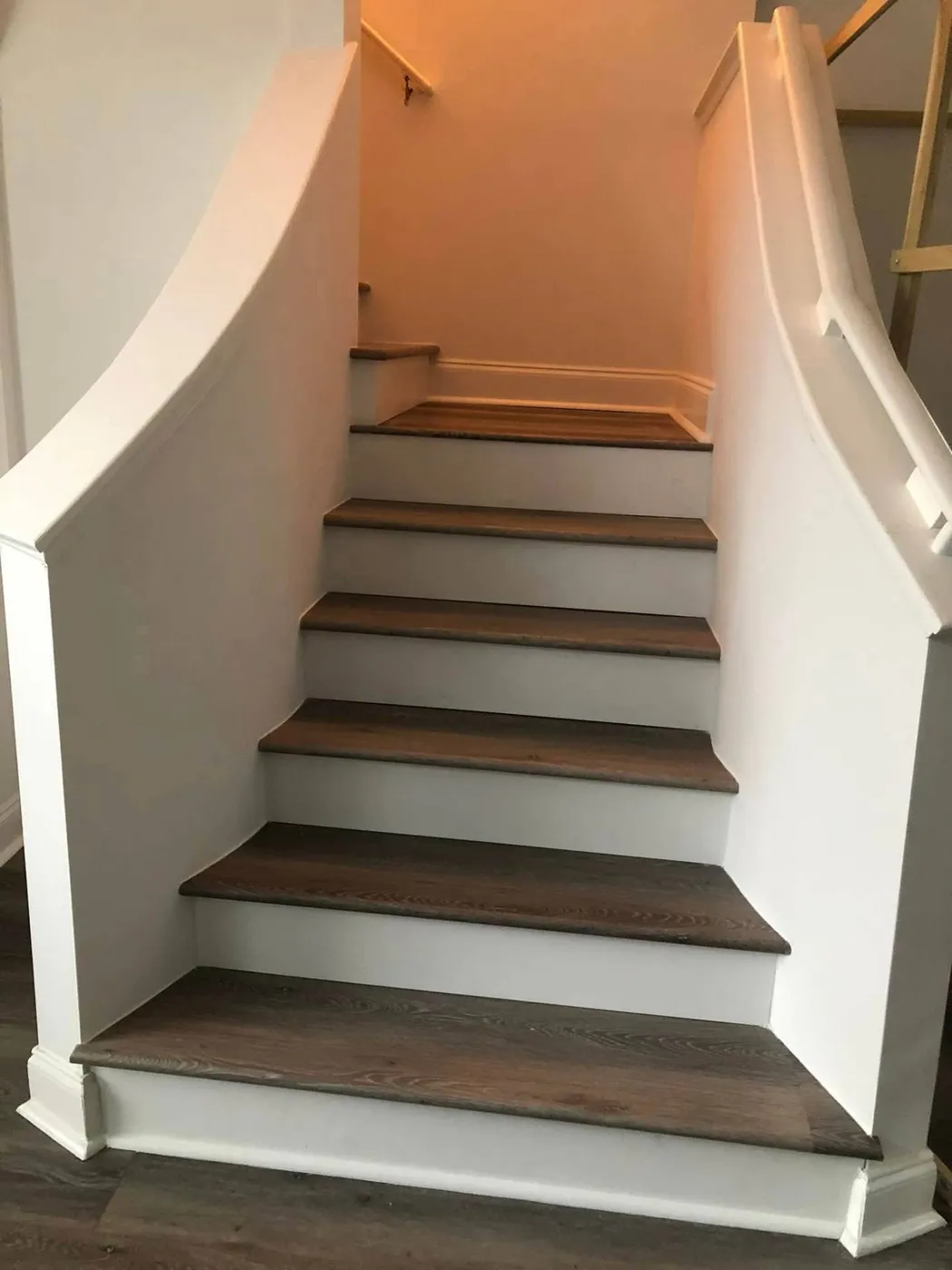 Curved staircase rebuild with custom hardwood treads by Lesher Contracting on 30A
