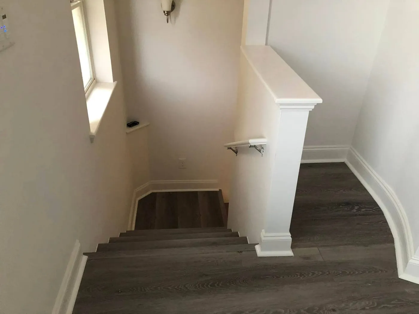 Stair landing finished with luxury vinyl plank flooring and new trim by Lesher Contracting in Santa Rosa Beach, FL