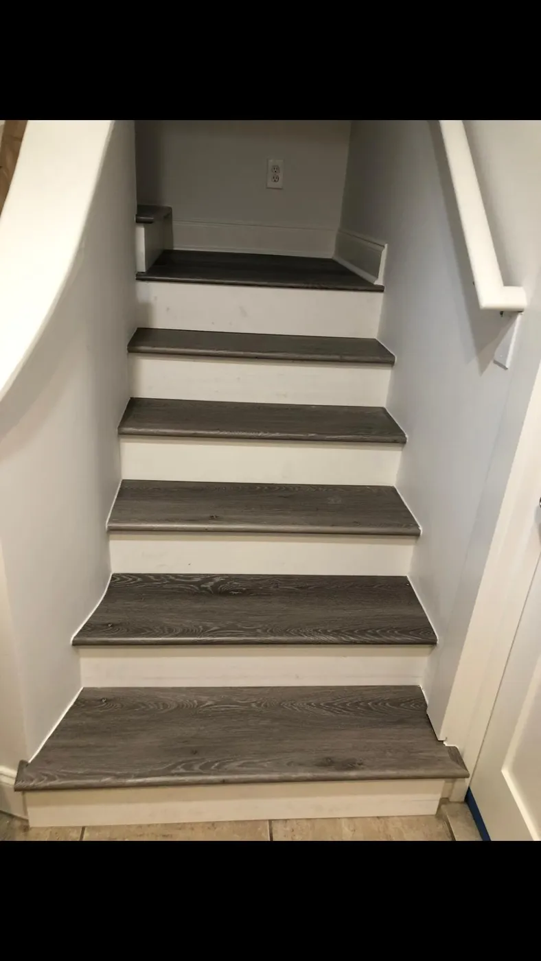 Close-up of newly installed gray oak stair treads in a 30A custom interior by Lesher Contracting